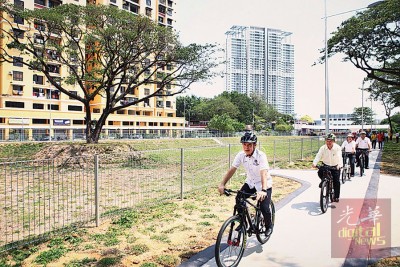 尤端祥(前起)、曹观友、林秀琴及郑来兴等人在防洪池公园内踏脚车,为甫建成的防洪池公园进行推介活动。