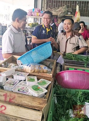 许汉宏(中)到巴刹向选民拜票。