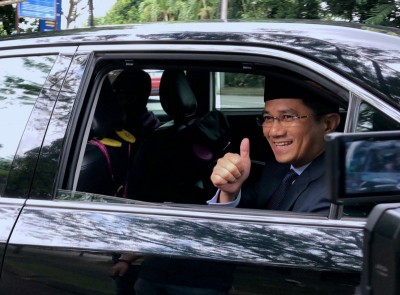 阿兹敏乘车进入武吉加央安行宫,向在场的媒体竖起拇指赞好。