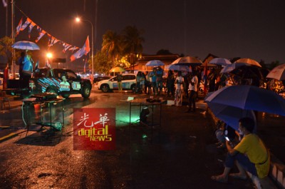 支持者在风雨中仍不离不弃,驻足聆听希望联盟讲座。