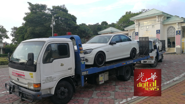 两辆拖车载走白色的马赛地轿车。