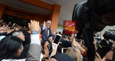 安华坐入房车前,向群众挥手。