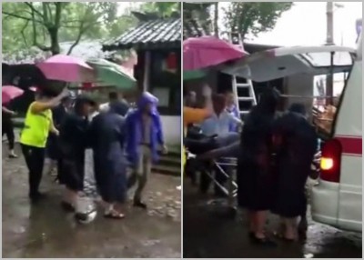 消防员将救出的被困人员抬上救护车送院治疗。