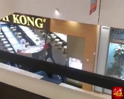 画面中可见匪徒用锤子敲打玻璃橱柜。