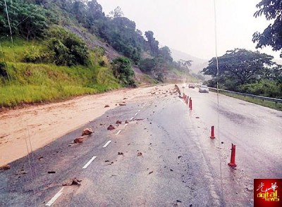 山坡发生土崩,大量沙石坠滚至道路。