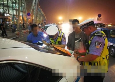 执法人员向违停的“网约车”开出罚单。
