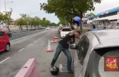 嫌犯以头盔砸破轿车大镜。
