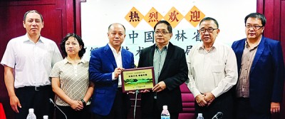 徐德辰(左3)在嘉宾陪同下颁发纪念品予郑荣兴(右3)。左1为任俊龙、于荔欣、黄天隆及郑文胜。