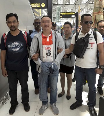 嫌犯由8名來自柔州刑事組警員押送回國。（馬新社照片）