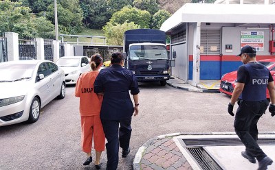 女嫌犯身穿橙色囚衣被警方带离法庭。
