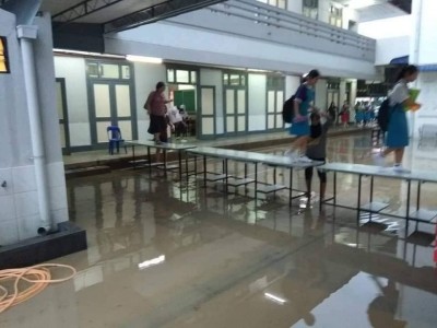 学生走在桌子上避开积水。