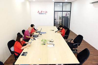 本报职员在吉玻新闻中心新办事处上班。