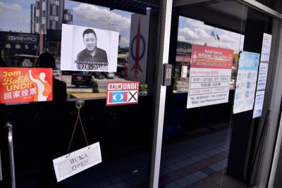 职员们在服务中心玻璃门上张贴黄田志黑白肖像,以悲痛心情悼念。