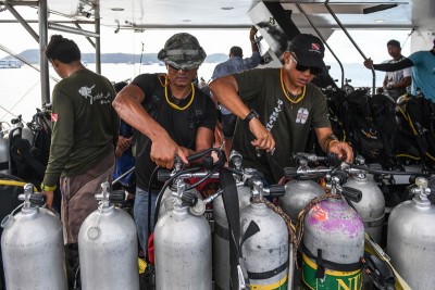 潛水隊員正准備氧氣樽，將潛入水底搜索。（法新社照片）