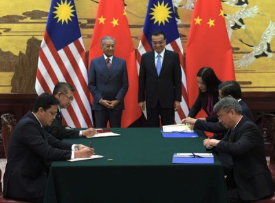 马哈迪(立者左)同李克强以平民大会堂见证马中双边表示签署谅解备忘录,当强化吉隆坡及北京市策略伙伴关系的标志。关于备忘录涉及农业及农业原 产品领域的搭档。