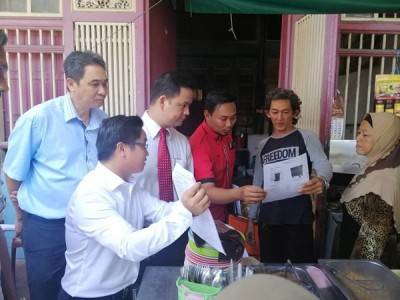 王宇航 (左)向居民派发通告,促请居民妥善处理垃圾源头分类。