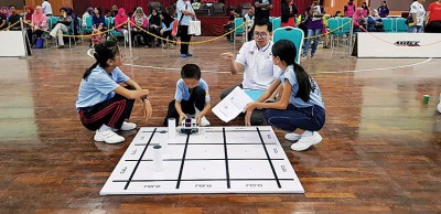 学生互相配合将机械人赛题完成。