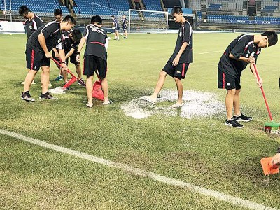 台北田径场下午大雨,工作人员紧急清除积水。