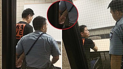 刘强左为铐上手铐带入警局照片曝光。