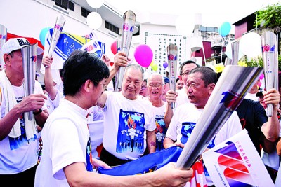 郑奕南(中)接领其中一支火炬,右起是王孙文、杨旺成。