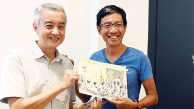 梅志雄先生（右）现场即兴素描送予赖国芳老师。
