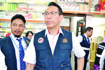 吉打州卫生局主任诺希占(右)亲自率领卫生局官员突击检举双溪大年区烈酒售卖店。