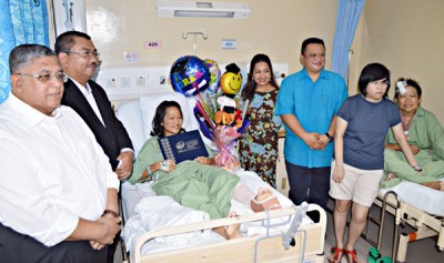玻州王储偕妃(右3与4)在医院病房内亲手颁发毕业证书、毕业花束及气球给吴秀娟(左3躺者),同时慰问其母亲江雪鸣(右1)及姐姐吴宝娟(右2)。左1及2:玻马大前校长拿督卡玛鲁丁及校长祖阿兹哈。