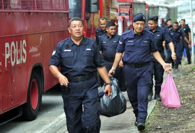 两名警员从斯里马哈马里安曼兴都庙带走垃圾。