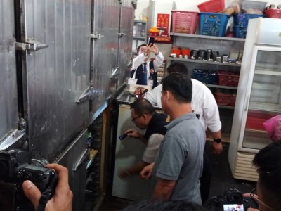 执法人员正在检查该点心楼内的冰箱。