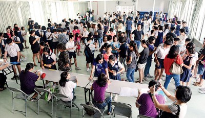 槟华小学礼堂内可见大批学生在成就放榜之际,陆续排队领取成绩单。