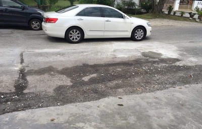 市局工程组官员前往民众自行修补的坑洞观察,发现该处有下陷迹象。