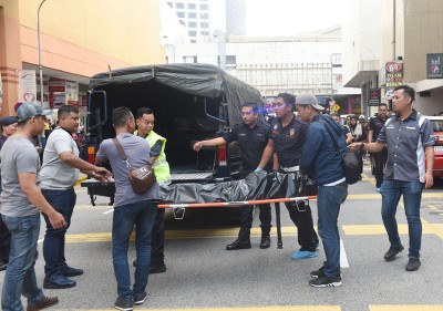 警员准备将死者遗体送往太平间停放。