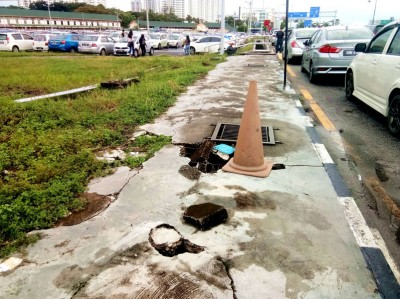 距B区停车场不远处的人行道路面出现严重破损。(本报摄于12月19天)