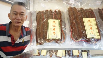 德记食品公司出售本地制作的腊味。左为张万道。