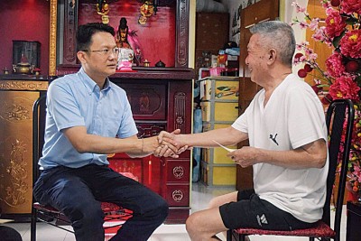 杨顺兴（左）也资助杨源发一笔医疗费用和生活开销。
