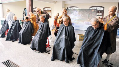 法师们为参与者剃度。