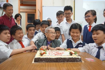 小学生在朱校长回校日当天,与她一起欢庆生日。(档案照)