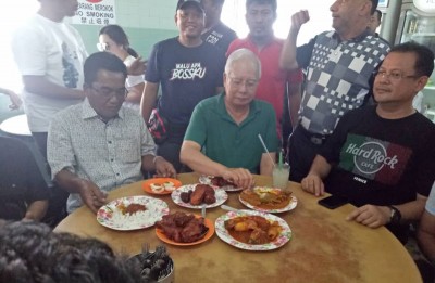 前首相纳吉周六在怡保著名的扁担饭档品尝美食。
