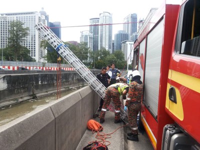 消拯员利用云梯与绳子,准备从大道下吊起尸体。