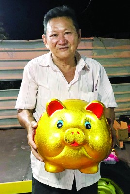 林金福手拿“金猪”提早祝贺各界新年快乐。