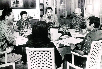 李光耀家人2001年共进晚餐。李光耀（右2）左手边起坐着妻子柯玉芝、女儿李玮玲、长孙女李修齐（背对镜头）、幼子李显扬与妻子林学芬（位置被遮挡）、长媳妇何晶及长子李显龙。