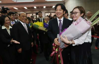 赖清德（前右2）在交接仪式后接受同仁献花并合影。（中央社照片）