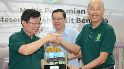 石礼兴赠送纪念品给曹观友,中为林冠英。