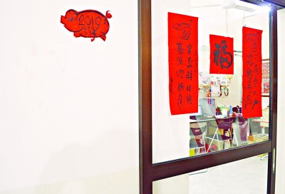 郭春安客厅的墙壁贴上亲手切割的猪年剪纸及对联。