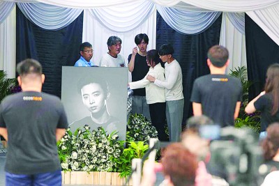 冯妈妈在亲人的携手下拉棺哭泣。