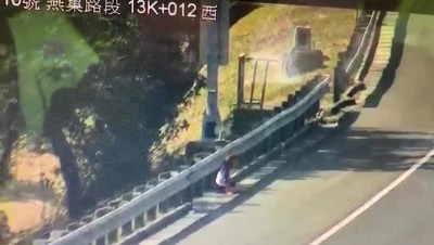 孙姓女子遭丈夫在车上刺伤后，在高速公路跳车逃生，然后坐在路边待援。