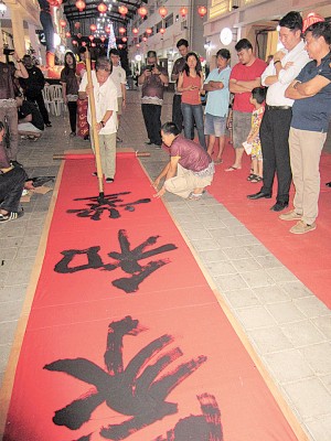 书法大师梁永即席挥写巨型对联，右2为黄思敏。