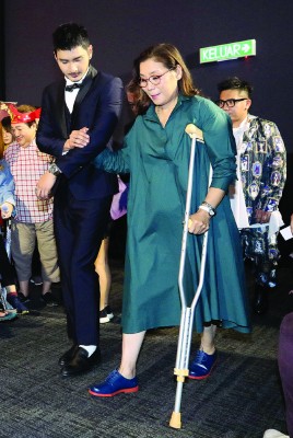 杨盼盼在吕锐的搀扶下，手拄拐杖步入戏院，与媒体一同观赏电影播出。