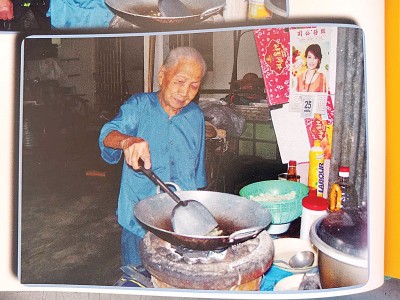 高龄的梁瑞欢在厨房自行烹饪。