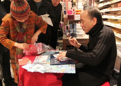 设计这些邮票的陈江洪（右）为民众签名。